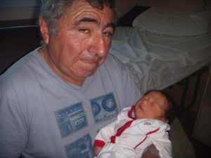 Juan Pablo Martínez Cepeda en brazos de su abuelo, Alejandro Cepeda, vecino de la calle Longone y fanático de Boca.