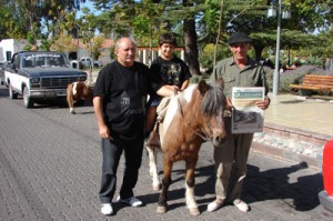 El Flaco Brecia atiende presto al gringo Sperdutti, quien vino desde Maipú para andar en pony con su hijo, por la plaza de nuestro pueblo.